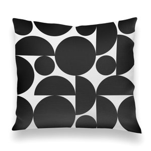 May include: Black and white geometric pattern pillow cover with a repeating design of circles and semi-circles.