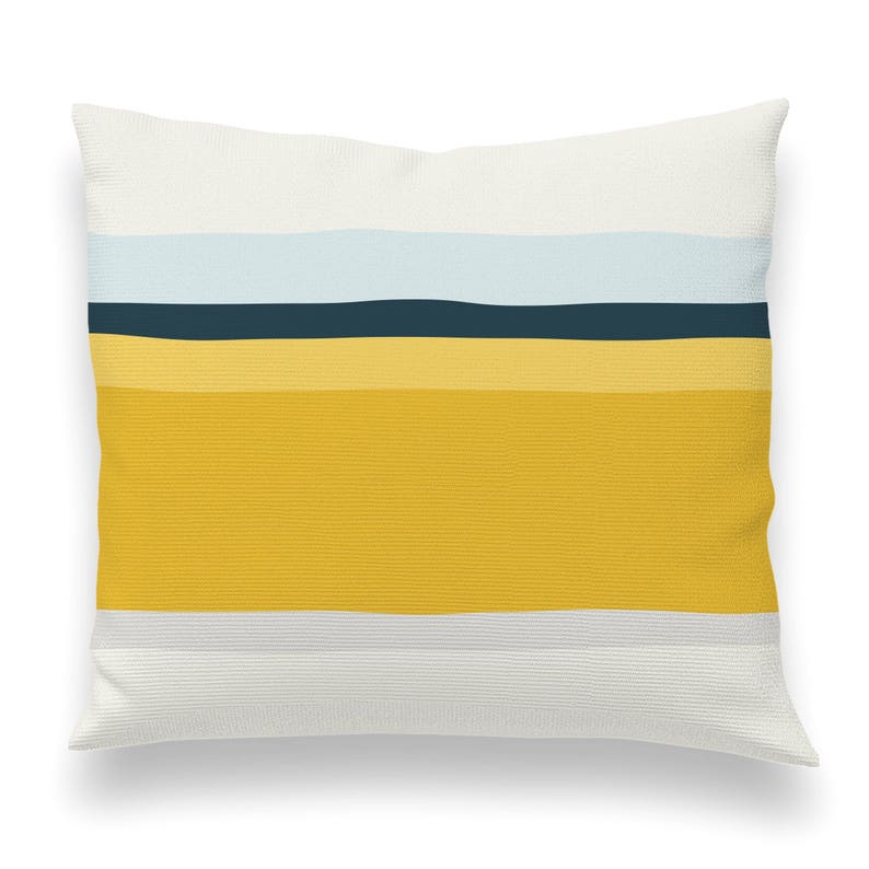 May include: A white throw pillow with a horizontal stripe pattern in shades of yellow, blue, and gray.