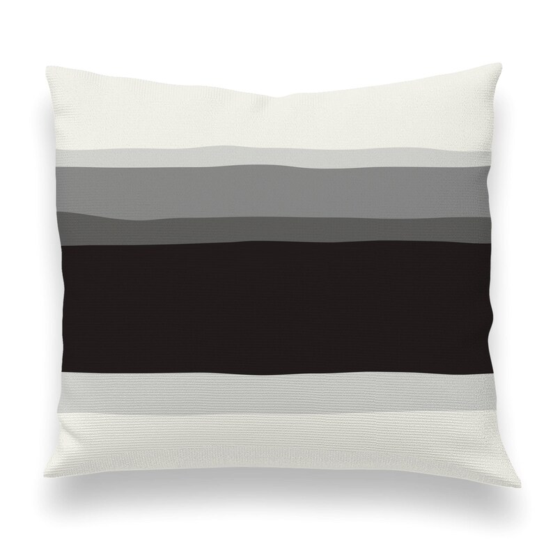 May include: A white pillow with a black and gray striped pattern. The stripes are horizontal and have a slightly wavy texture.