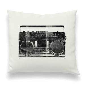 May include: A black and white vintage boombox with a distressed look. The boombox has a cassette player and two speakers.