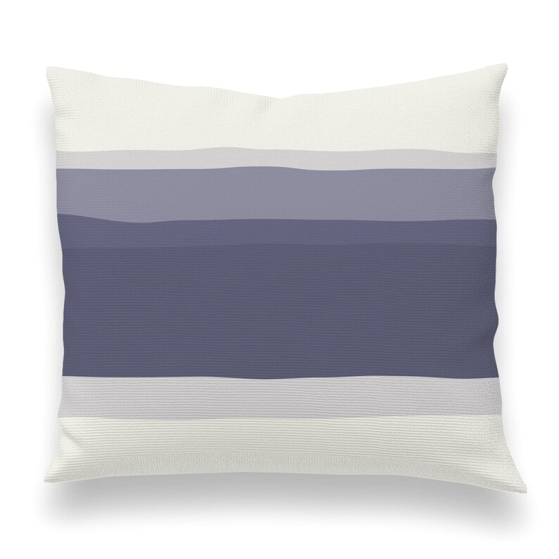 May include: A white throw pillow with a horizontal stripe pattern in shades of gray and blue.