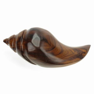 May include: A handcrafted, polished wooden conch shell. The shell is a rich, dark brown with visible wood grain patterns. The conch shell is a decorative item, perfect for coastal or nautical themed decor.