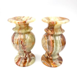 Puede incluir: Un par de candelabros de mármol verde, marrón y naranja. Los candelabros están hechos de ónix y tienen un diseño clásico y elegante.