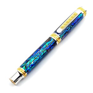 Op de afbeelding: Een blauwe en groene abalone-schelp pen met gouden accenten en een zilveren clip.