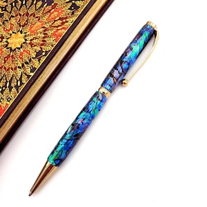 May include: A blue and green patterned pen with a gold clip and tip. The pen is made of abalone shell.