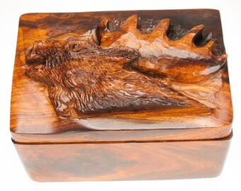 May include: A wooden box with a carved moose head on the lid. The box is made of dark wood with a rich grain pattern.