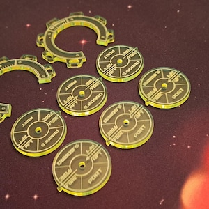 Può includere: Un set di otto pezzi da gioco in plastica gialla. I pezzi sono circolari con un centro rialzato e un design stampato. Il design include le parole "CRUISER" e "PORT".