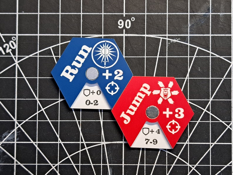 Puede incluir: Dos piezas de juego hexagonales, una azul con la palabra "Run" y la otra roja con la palabra "Jump". Ambas piezas tienen un escudo blanco con un rango de n&uacute;meros y un signo m&aacute;s con un n&uacute;mero.