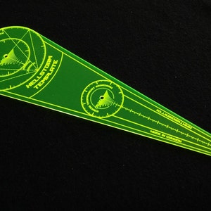 May include: A neon green Hellstorm Template made in Canada. The template has circular and linear measurement markings, with the text "Hellstorm Template" and "Flight Instruments Series".