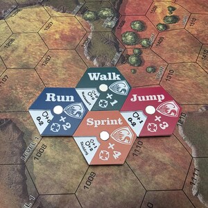 Pode incluir: Cinco pe&ccedil;as de jogo hexagonais com diferentes op&ccedil;&otilde;es de movimento: Andar, Correr, Sprintar, Saltar. Cada pe&ccedil;a tem uma cor diferente e um n&uacute;mero de espa&ccedil;os para se mover. As pe&ccedil;as est&atilde;o dispostas em c&iacute;rculo num tabuleiro de jogo castanho e verde.