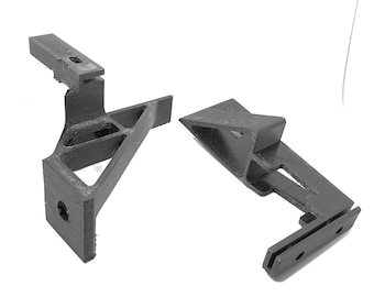May include: Two black plastic 3D printed brackets with a triangular shape and multiple holes.