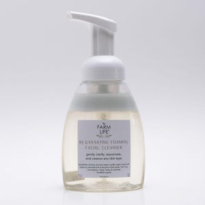 May include: A clear, plastic bottle of The Farm Life Rejuvenating Foaming Facial Cleanser. The bottle has a white pump and a label with product information. The cleanser is designed to gently clarify, rejuvenate, and cleanse any skin type.