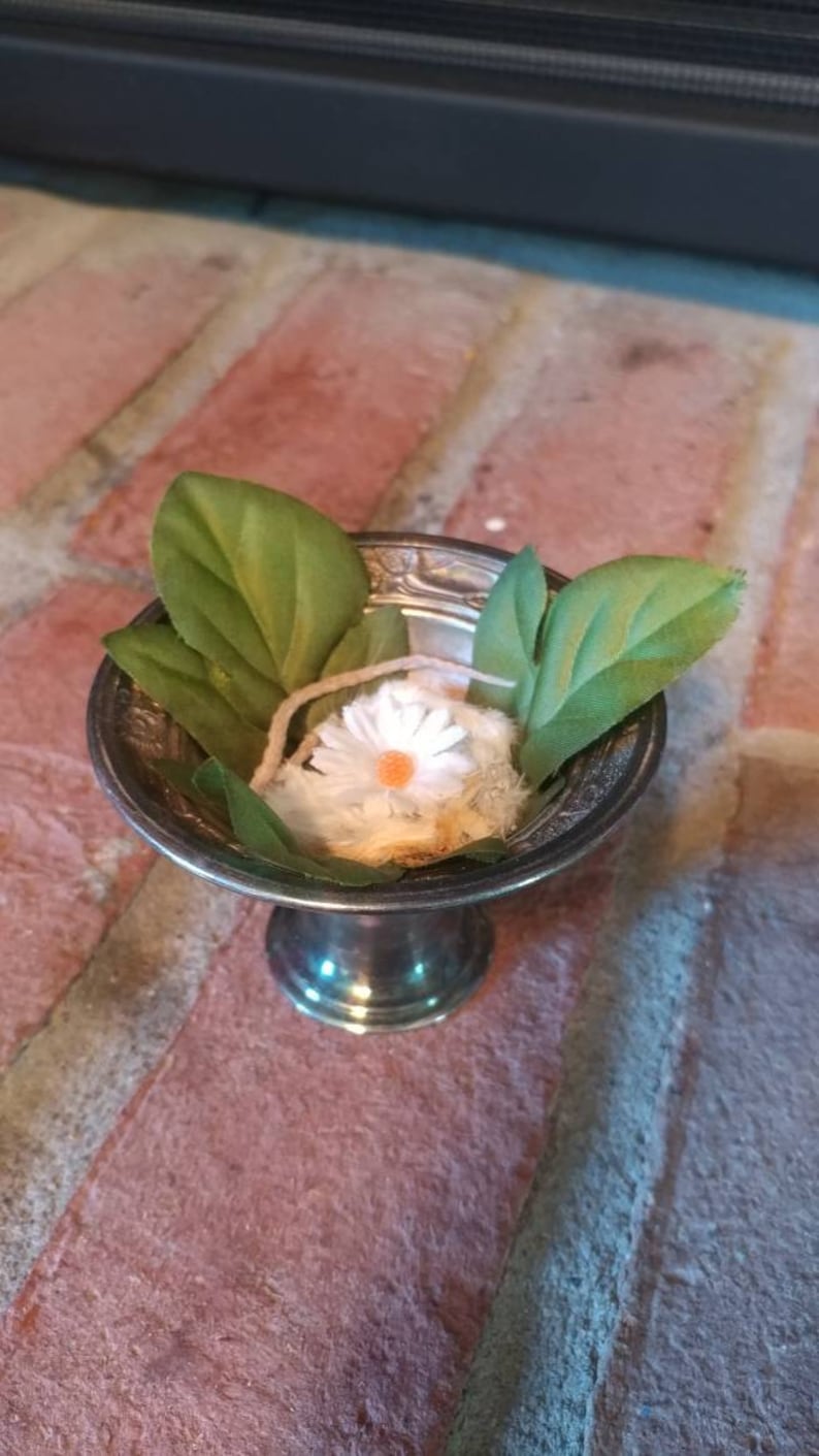Dried feeder mouse in metal stand with faux leaves and flower