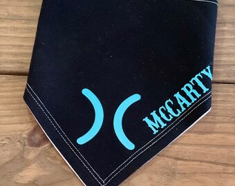 May include: Black bandana with white stitching and a turquoise blue design of two curved lines and the word "MCCARTY" in a stylized font.
