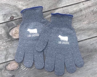 May include: A pair of gray work gloves with a white cow silhouette and the text "Lark Livestock" on each glove.