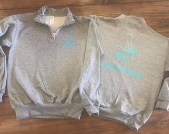 May include: Two gray sweatshirts with a teal blue logo. The logo on the left sweatshirt says "AH" and "Andrews Ranch". The logo on the right sweatshirt says "AH" and "Andrews Ranch".