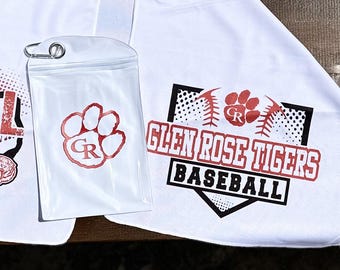 May include: White towel with a red and black baseball logo. The logo features a paw print with the letters "GR" inside. The text "Glen Rose Tigers Baseball" is written below the paw print.