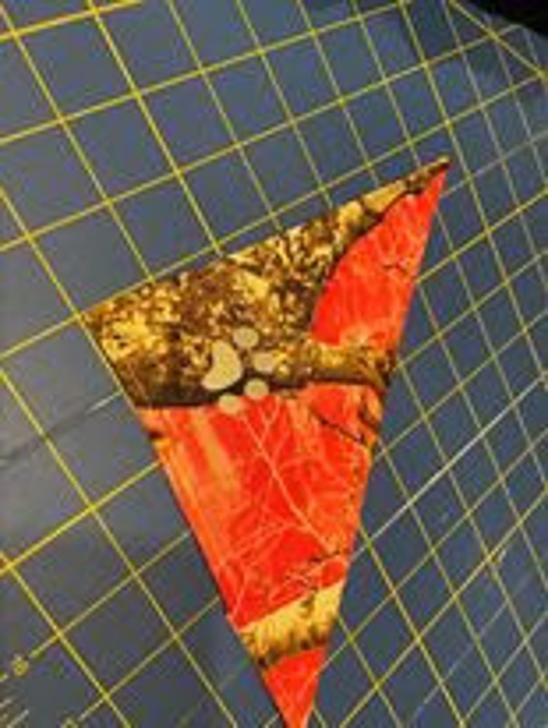 May include: A pink, brown, and white camouflage bandana with a triangular shape.