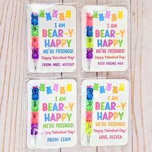 May include: Four Valentine's Day cards with colorful gummy bear pens. Each card reads "I AM BEAR-Y HAPPY WE'RE FRIENDS! Happy Valentine's Day!" with different names. The pens are made of stacked gummy bear shapes in various colors.