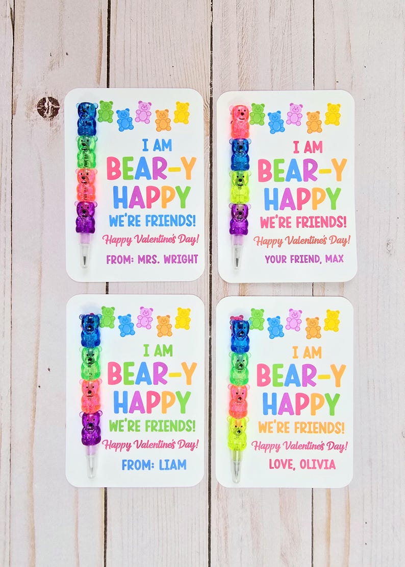 May include: Four Valentine's Day cards with colorful text and bear-shaped pen toppers. Each card reads "I AM BEAR-Y HAPPY WE'RE FRIENDS! Happy Valentine's Day!" with a different name at the bottom. The pens have blue, green, pink, and purple bears.