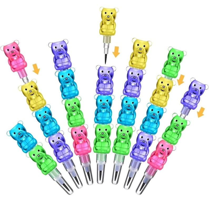 May include: A collection of colorful, novelty mechanical pencils. Each pencil features a stackable design with a bear-shaped eraser topper in various colors, including pink, yellow, blue, green, and purple. The pencils are arranged in a fan-like pattern.