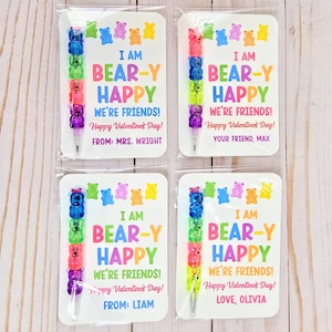 May include: Four Valentine's Day cards with colorful gummy bear pens. Each card reads "I AM BEAR-Y HAPPY WE'RE FRIENDS! Happy Valentine's Day!" with different names. The pens are made of stacked gummy bear shapes in various colors.
