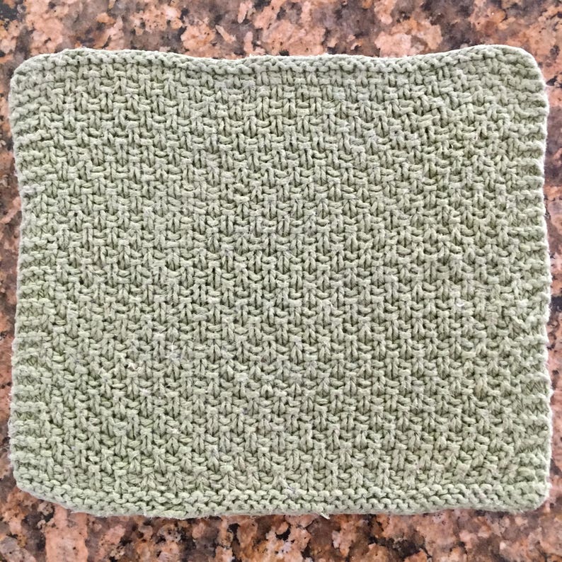 May include: A green knitted dishcloth with a textured pattern.