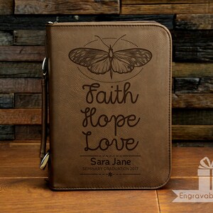 May include: Brown leather journal with a butterfly design and the words "Faith Hope Love" engraved on the front. The journal also has the text "Sara Jane Seminary Graduation 2017" engraved on the front.