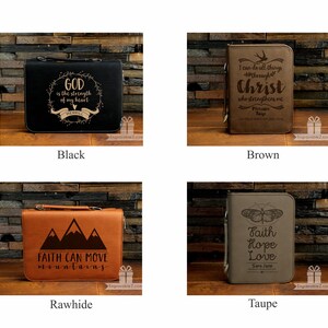 May include: Four leather Bible covers in black, brown, rawhide, and taupe. Each cover features engraved text and designs, including inspirational quotes and mountain graphics. The covers have a handle and zipper closure.