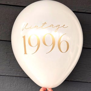 30th Birthday Balloon .  A white balloon with gold text that reads "Vintage 1996".  The balloon is round and inflated.