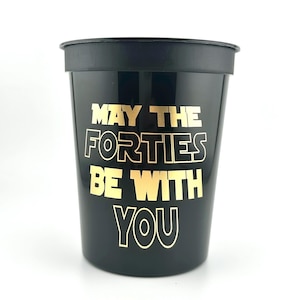 A black plastic stadium cup printed with gold text reading May the Forties be with you.