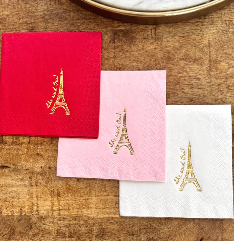 Cocktail napkin featuring “She Said Oui” text and Eiffel Tower illustration in foil stamping