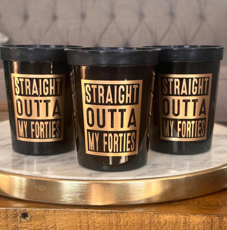 black 16 ounce stadium cups that read Straight outta my Forties in a gold metallic font.  These are 50th Birthday Cups