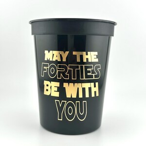 A black plastic stadium cup featuring gold printed text that reads May the Forties be with you.