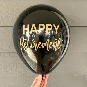 black latex balloon with gold lettering that reads "HAPPY Retirement". Black and gold retirement balloons