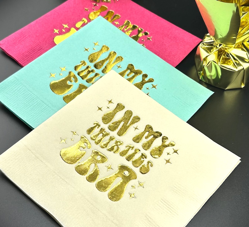 Pode incluir: Tr&ecirc;s guardanapos de papel com letras douradas. Os guardanapos s&atilde;o rosa, azul claro e branco. O texto nos guardanapos diz "In My Thirties Era".