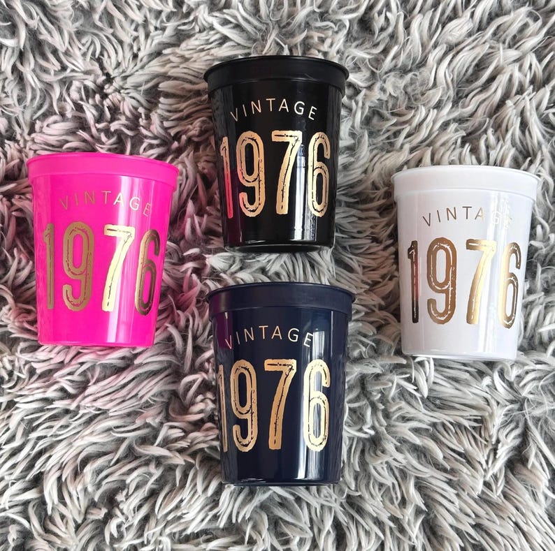 plastic stadium cups 16 ounce that read Vintage 1976 in a gold metallic font.  Cups are black, navy, white and hot pink.  50th Birthday Reusable Cups