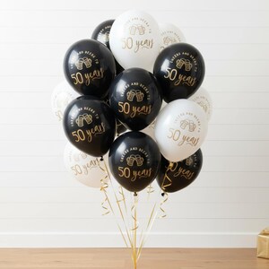 50th Milestone balloon set.  Black and White latex balloons with gold text that reads Cheers and beers to 50 years with two beer mugs.  50th Party Decorations