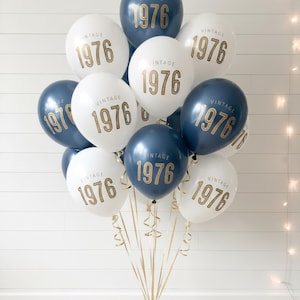 A balloon bouquet with navy and white latex balloons that read Vintage 1976 in a gold metallic font.  50th Birthday Balloon
