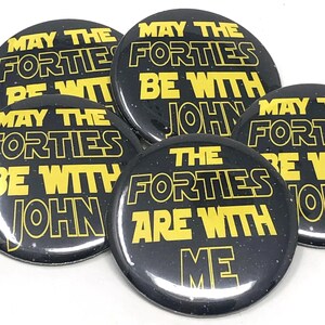 Five round black button pins printed with yellow text reading May the Forties be with you.