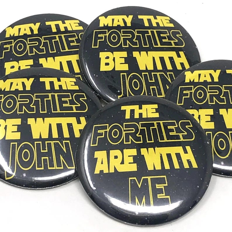 Five round black button pins printed with yellow text reading May the Forties be with you.