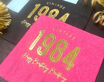 May include: Pink paper napkin with gold foil lettering that says "Vintage 1984 Happy Birthday Birthday".