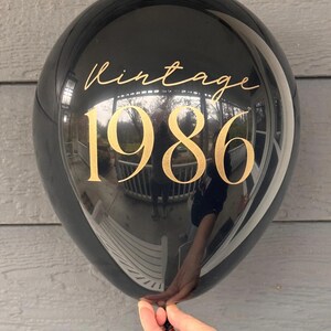 Black latex balloon that reads Vintage 1986 in gold text.  40th Birthday Balloon