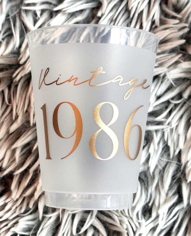 Frosted 16 ounce plastic reusable cup that reads Vintage 1986 in gold text.  40th Milestone Party Cup