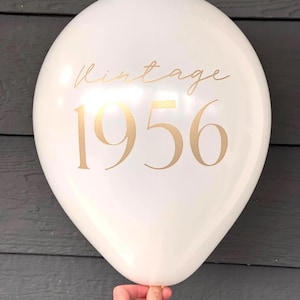 latex 12 inch balloon in white that reads Vintage 1956 in a gold metallic font.  70th Birthday Balloons