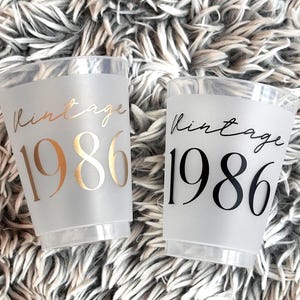 Frosted 16 ounce cups that read Vintage 1986 in black and gold text.  40th Birthday Cups