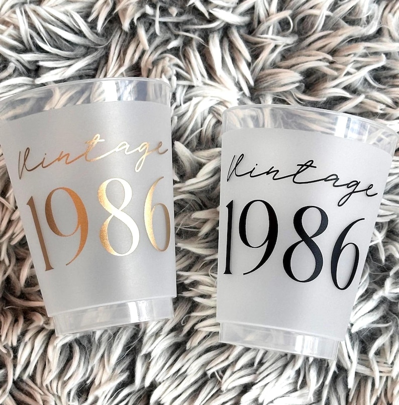 Frosted 16 ounce cups that read Vintage 1986 in black and gold text.  40th Birthday Cups
