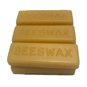 May include: Three rectangular blocks of beeswax, each with the word "BEESWAX" embossed on the top.