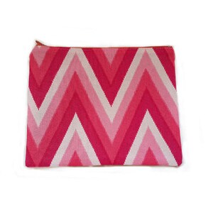 May include: A pink and white chevron patterned zippered pouch.