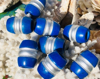 Puede incluir: Un grupo de cuentas de madera azules y plateadas. Las cuentas tienen un acabado liso y pulido y son perfectas para hacer joyas u otras manualidades.